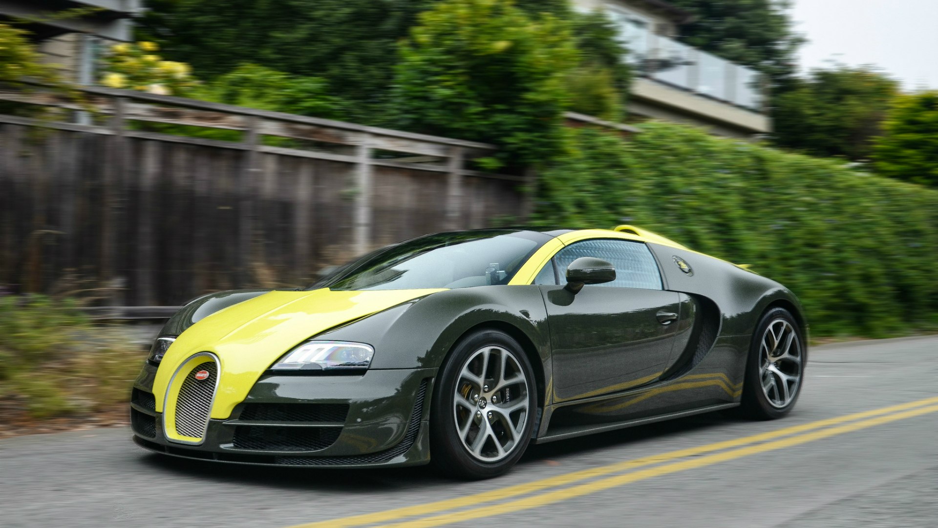 Черно-желтый Bugatti Veyron на выезде из небольшого городка